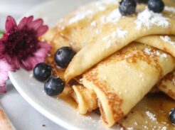 Folded sourdough discard crepes topped with powdered sugar and blueberries.