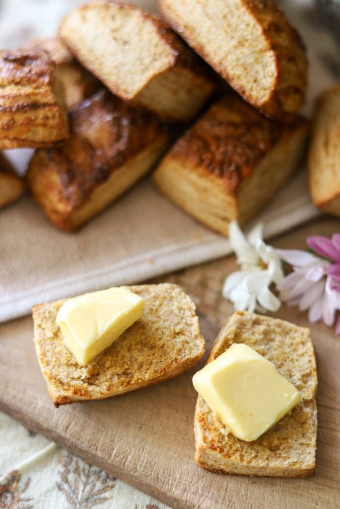 Close-up of biscuits with butter on a wooden board.