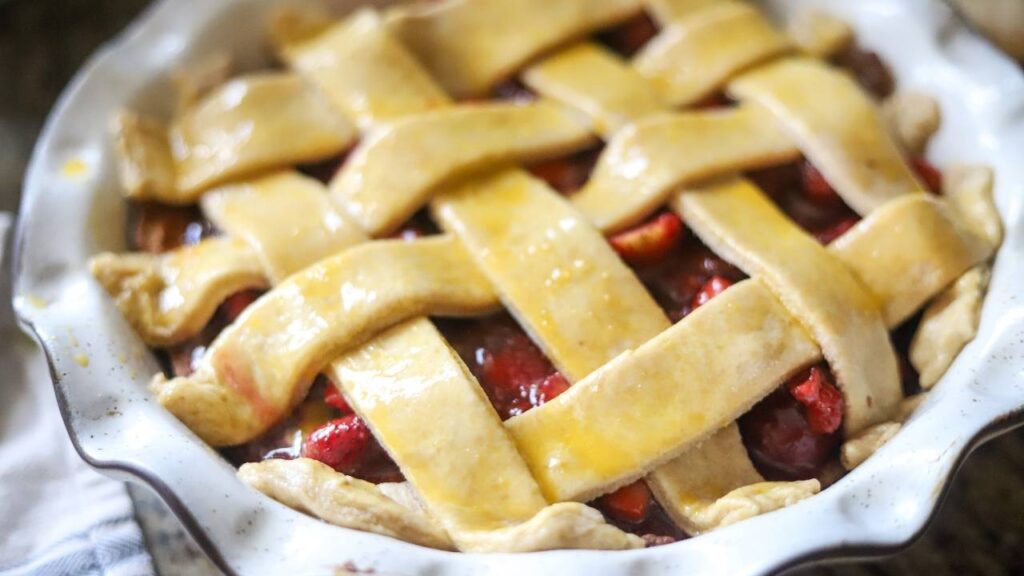 Unbaked strawberry pie with a golden egg-washed lattice crust.
