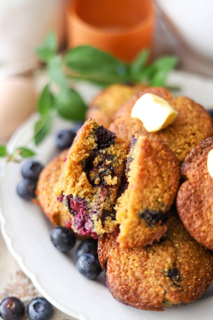 Close-up of a blueberry muffin broken open with juicy berries inside.