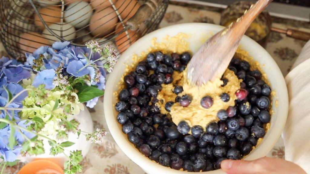 Bowl of blueberry muffin batter being stirred