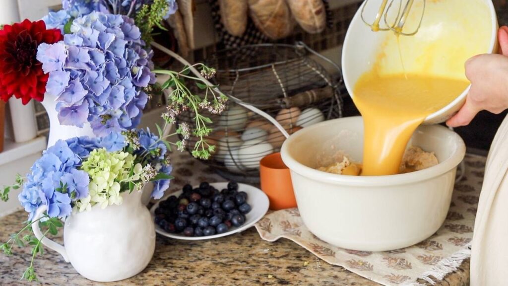 Pouring wet ingredients into a mixing bowl.