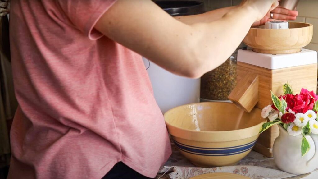 Woman grinding flour into a mixing bowl.