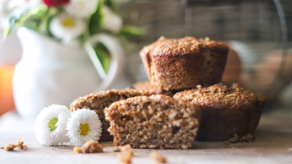Stack of muffins with one sliced open in front.