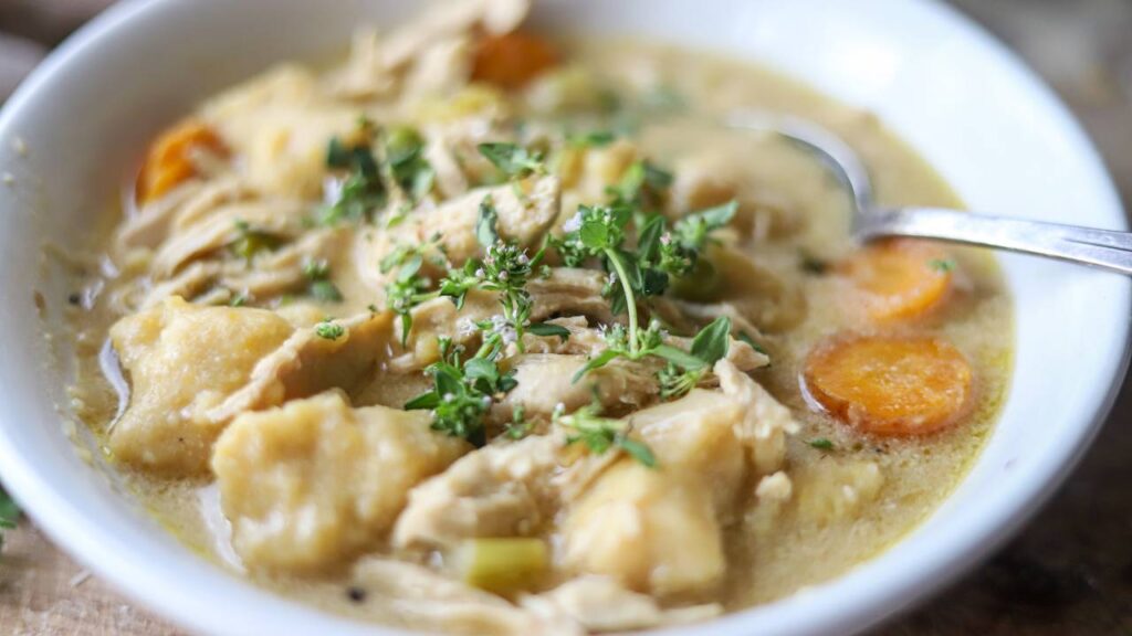 Close-up of creamy chicken gnocchi soup in a white bowl.