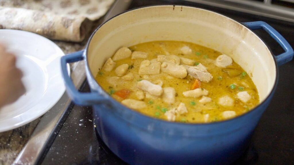 Dutch oven with chicken and gnocchi stew on the stove.