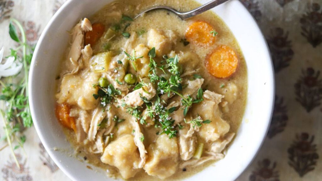 Top view of chicken gnocchi soup in a bowl with a spoon.
