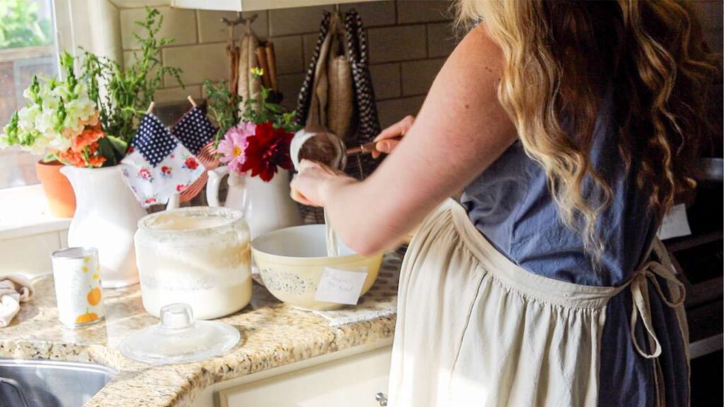 woman bulk prepping sourdough doughs for freezer meals
