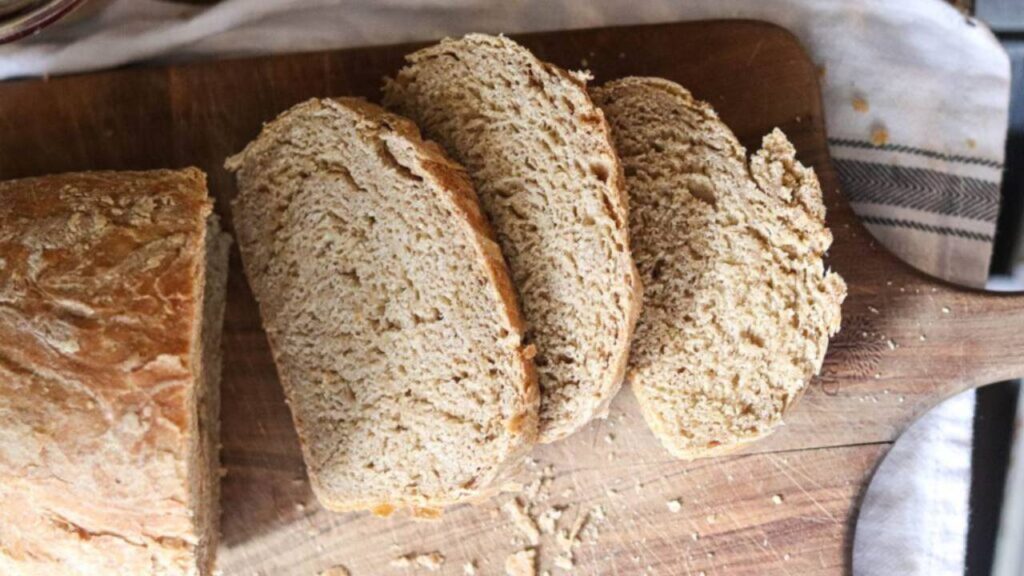 Sliced whole grain sourdough bread on a wooden board