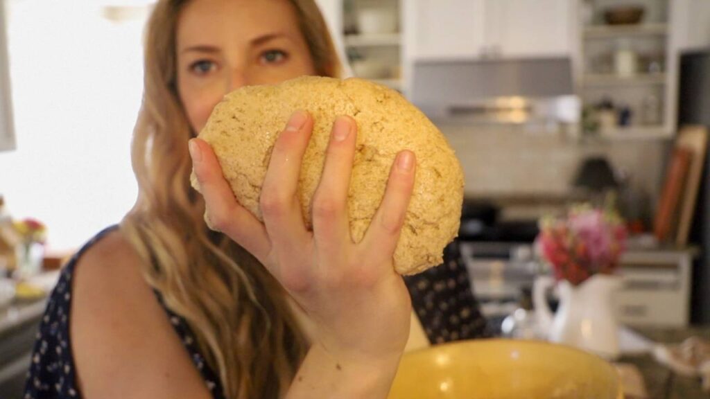 Holding a ball of whole grain dough in front of the camera