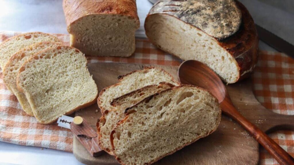 Two types of sourdough bread, both sliced on a cutting board