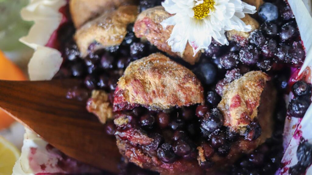 Close-up of golden biscuits baked into blueberry cobbler