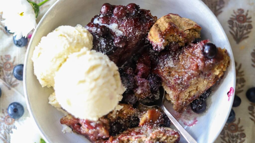 Overhead view of blueberry cobbler and ice cream in a bowl
