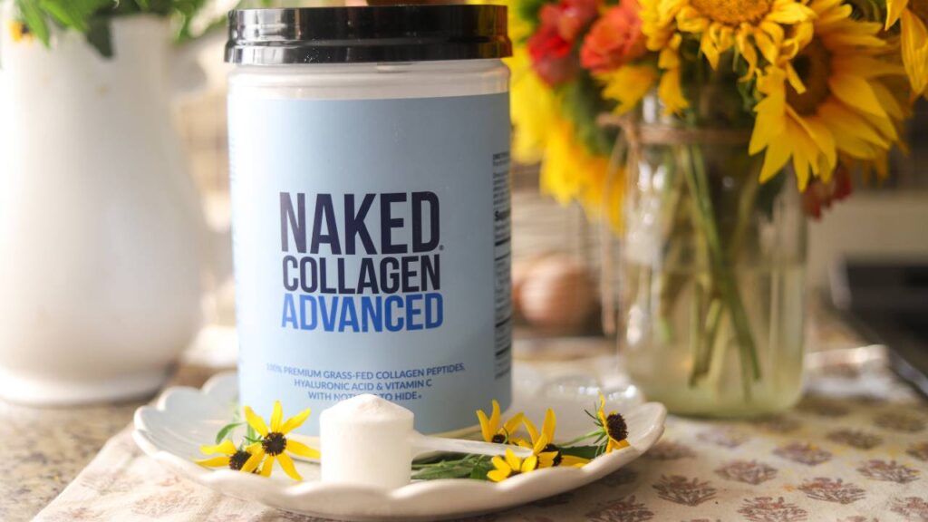 Naked Collagen Advanced container on plate with scoop and fresh flowers