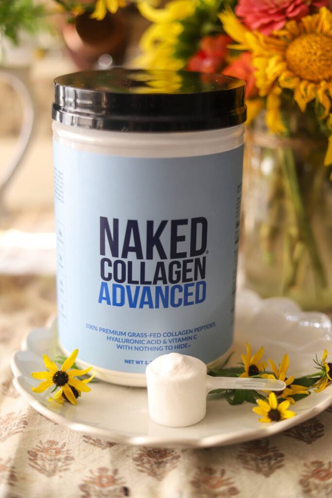 Close-up of Naked Collagen Advanced container with scoop and flowers