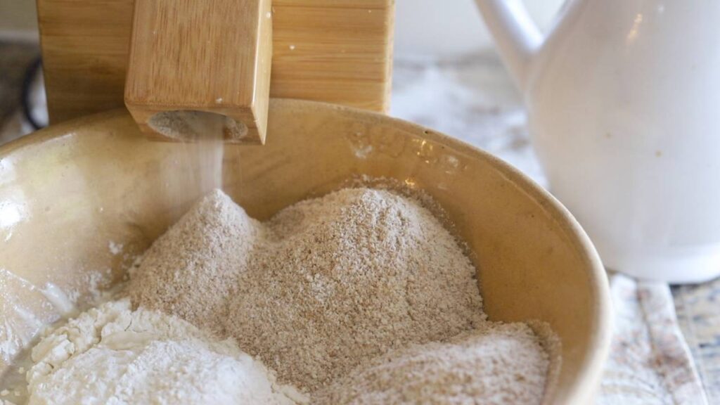 Freshly milled flour pouring into mixing bowl