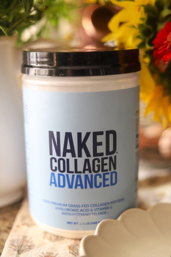 Close-up of Naked Collagen Advanced container with flowers in background