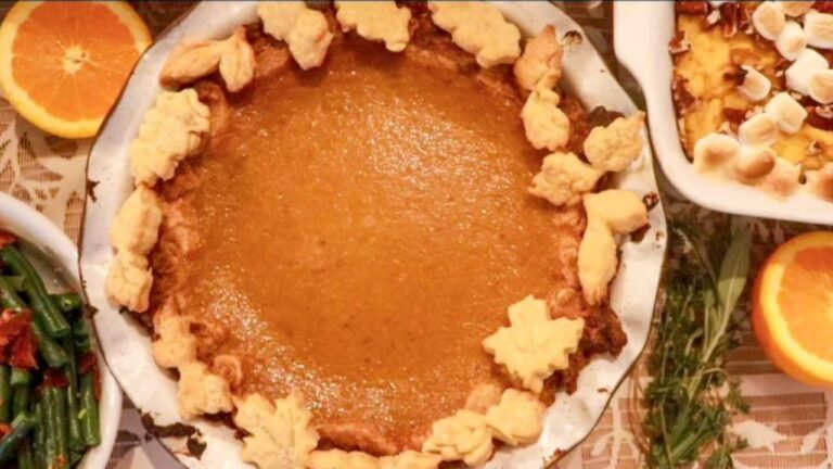 homemade pumpkin pie with leaf shaped crust decorated around the edges.