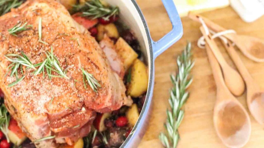 stockpot with pork shoulder, sides, and herbs