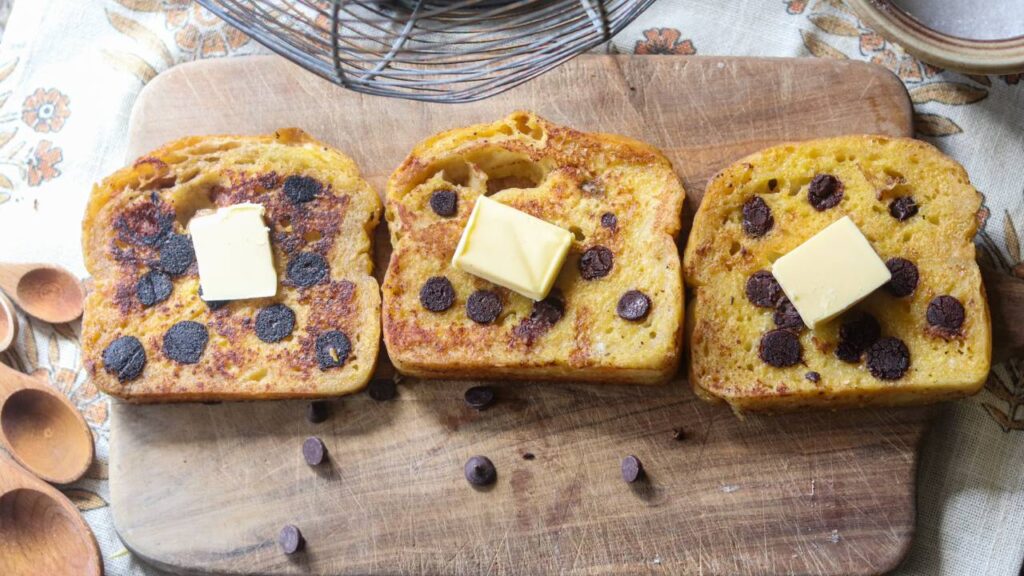sourdough french toast with chocolate chips on a cutting board with butter on top