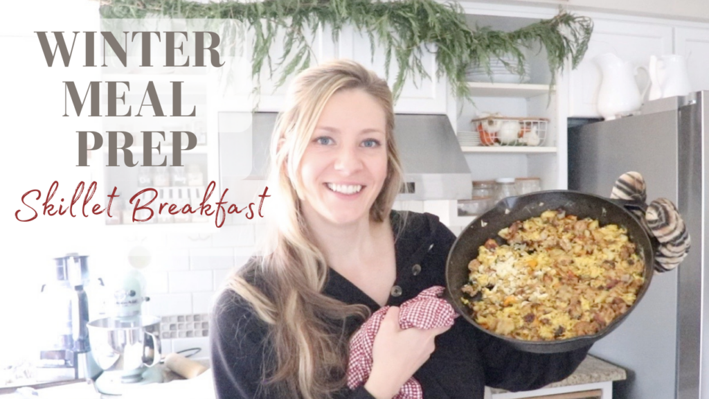 woman holding up a cast iron skillet with a homemade meal prep breakfast in it.