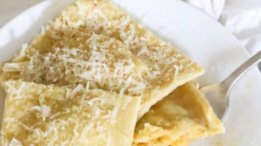 plate of homemade pasta ravioli with shredded cheese on top