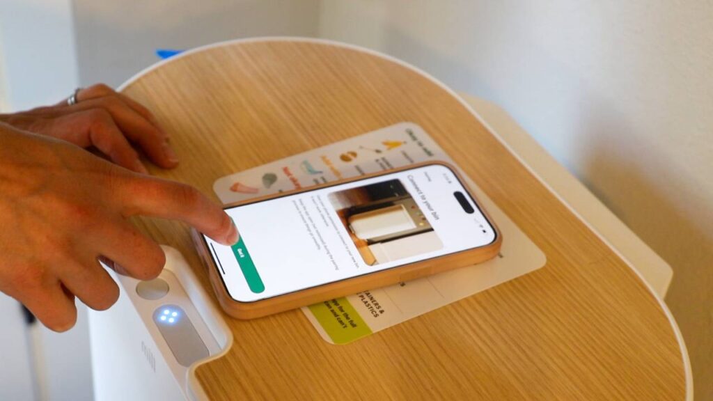 Hand using the Mill app on a phone during the setup process.