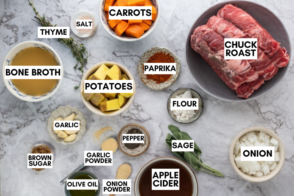 Ingredients for apple cider pot roast including chuck roast, potatoes, carrots, onion, garlic, bone broth, apple cider, herbs, spices, and flour.