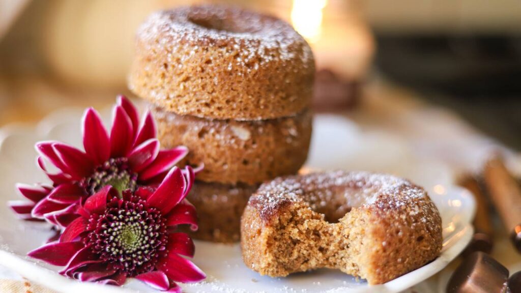 Stack of whole grain apple cider donuts with a bite taken out