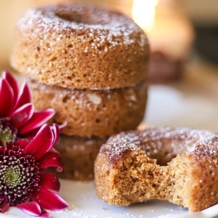 Stack of whole grain apple cider donuts with a bite taken out