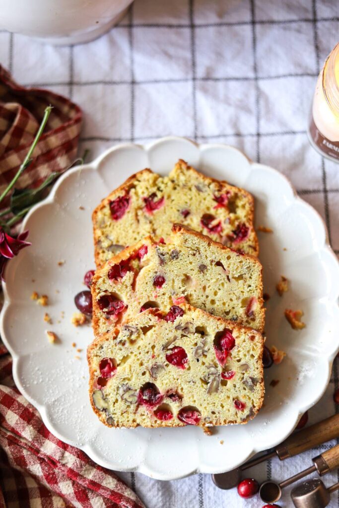 Sliced einkorn cranberry orange bread on a white plate