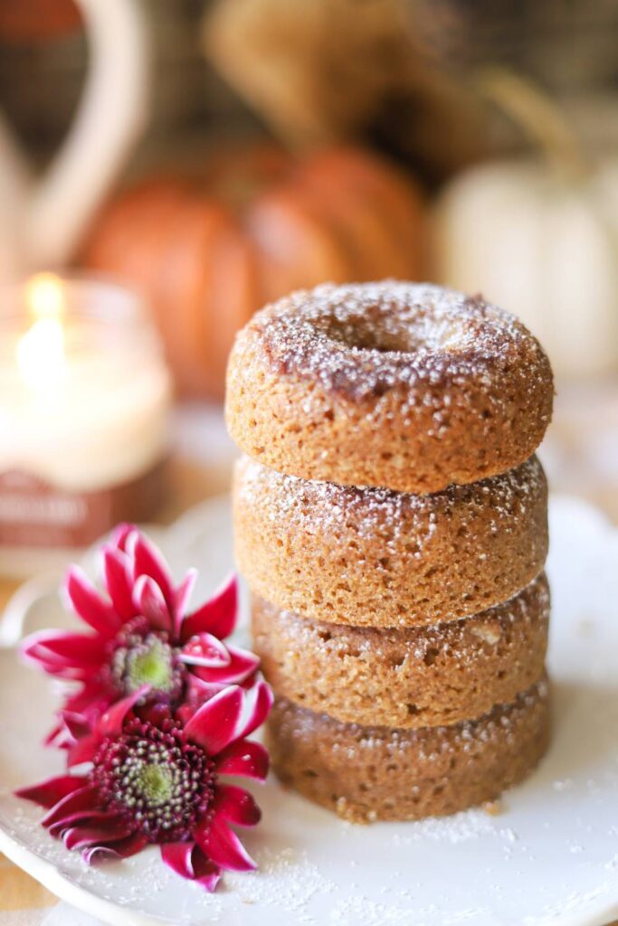 Whole grain apple cider donuts stacked on a plate