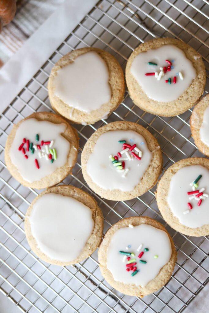 Iced whole grain sugar cookies with sprinkles on a wire rack