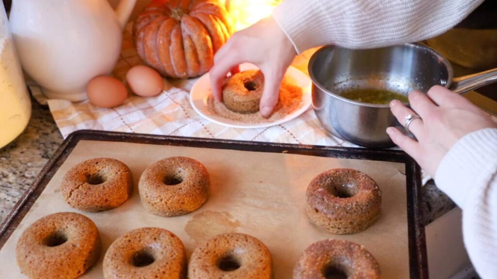Whole grain apple cider donuts cooling on a baking sheet