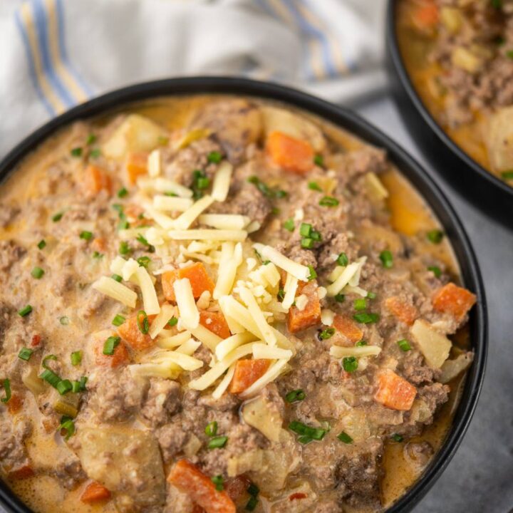 Bowl of healthy cheeseburger soup topped with shredded cheese and chives