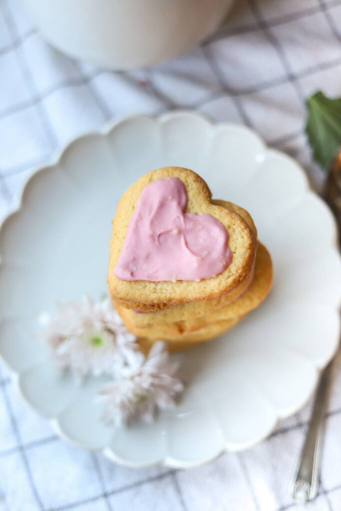 Stack of iced einkorn lemon sugar cookies on a white plate