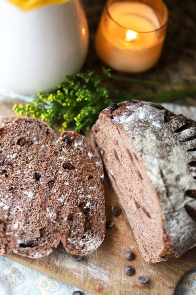 Sliced sourdough chocolate bread with candle and milk