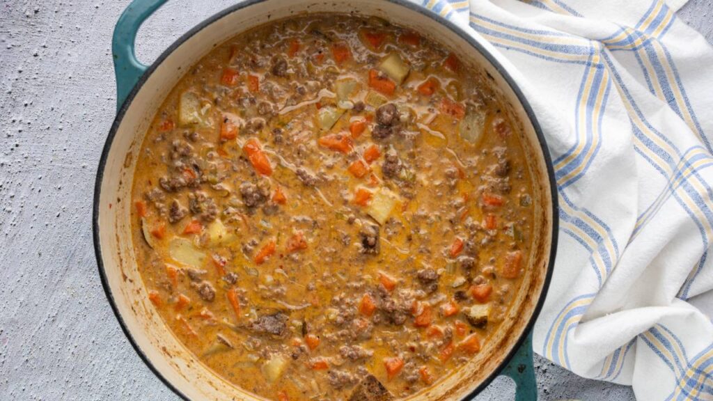 Cheeseburger soup simmering in a Dutch oven