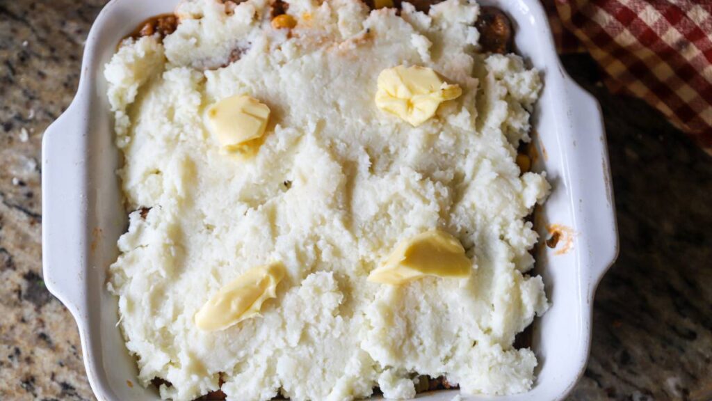 Mashed potatoes spread over shepherd’s pie filling before baking