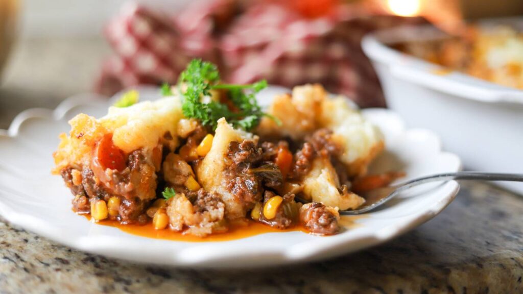 Plated shepherd’s pie with corn, carrots, and rich gravy