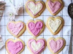 Iced heart-shaped lemon sugar cookies arranged on a kitchen towel
