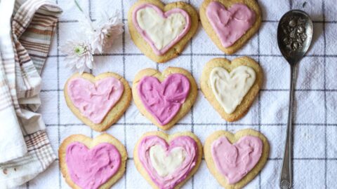 Iced heart-shaped lemon sugar cookies arranged on a kitchen towel