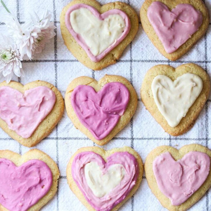 Iced heart-shaped lemon sugar cookies arranged on a kitchen towel