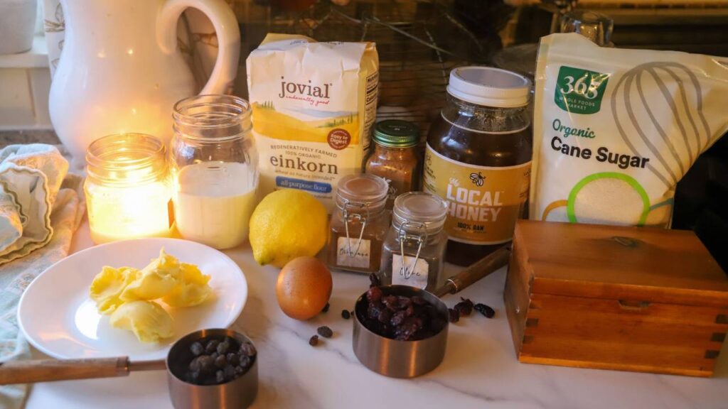 Ingredients for sourdough einkorn hot cross buns including einkorn flour, honey, spices, and dried fruit