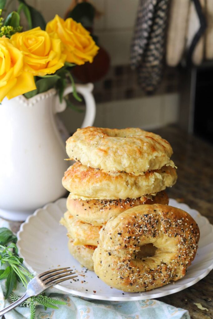 Stack of homemade einkorn sourdough bagels on plate in kitchen