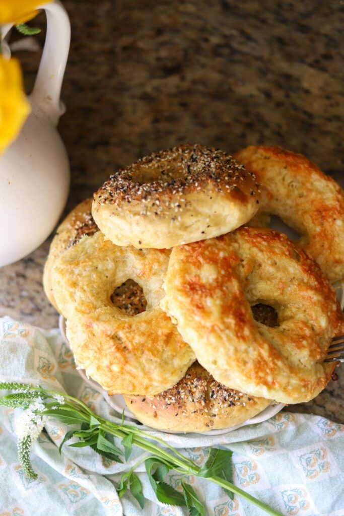 Plate of homemade einkorn sourdough bagels with cheese topping and everything seasoning