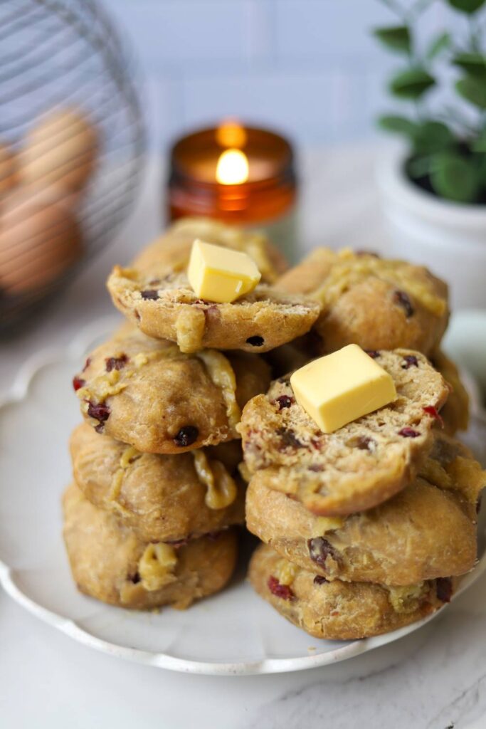 Sourdough einkorn hot cross buns with butter on a plate