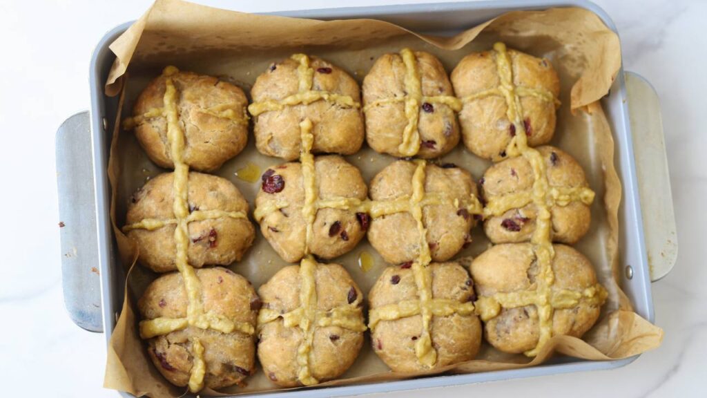 Overhead view of sourdough einkorn hot cross buns in baking pan