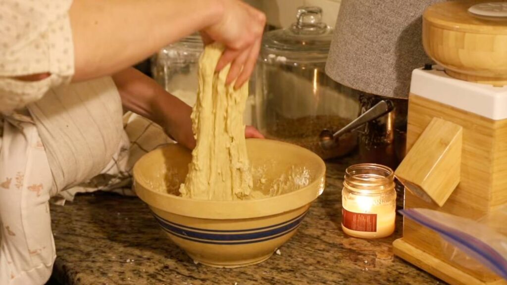 Stretching sticky sourdough bagel dough in mixing bowl