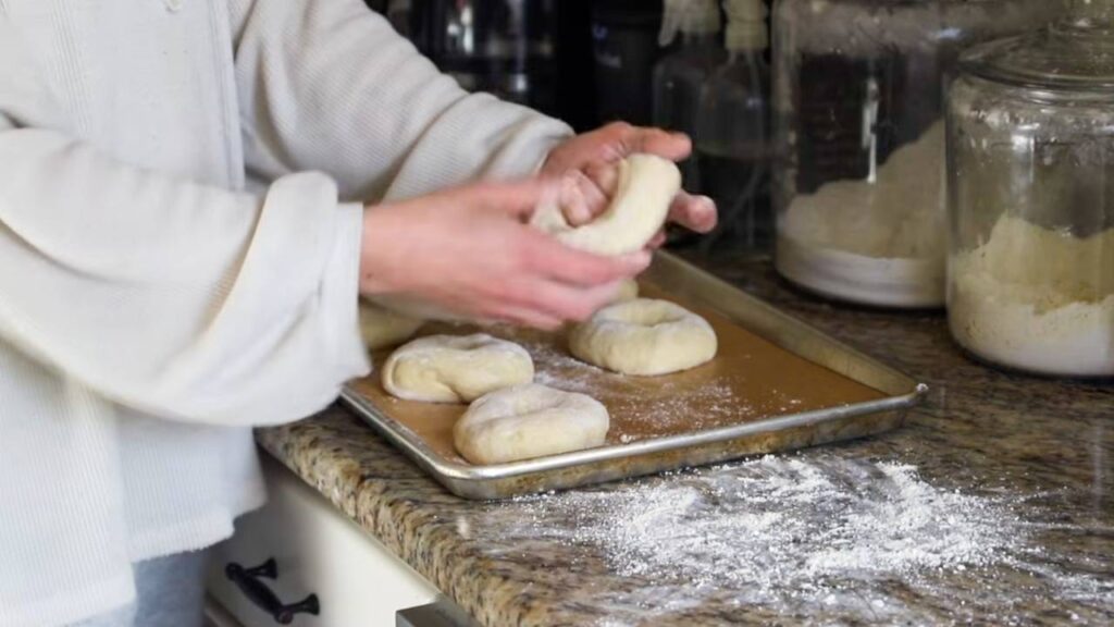 Shaping einkorn sourdough bagel dough on baking sheet